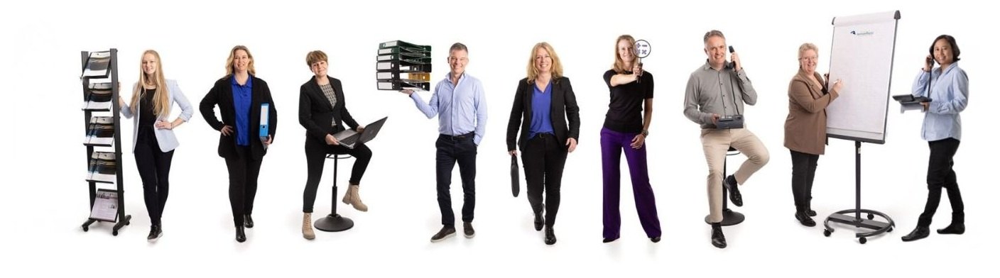 Het team van Aemstelhorst: negen medewerkers, staand en poserend met kantoorattributen zoals ordners, een flip-over en een telefoon
